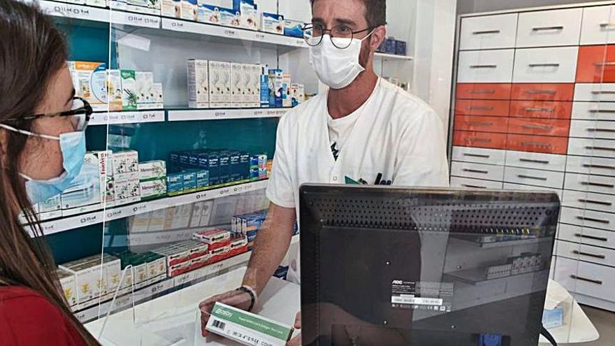 Un farmacéutico vende una de las pruebas covid.