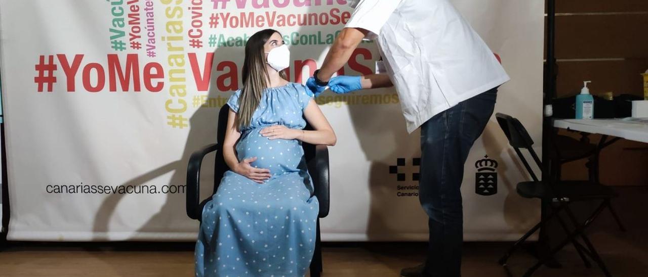 Una embarazada recibe la vacuna contra la gripe.