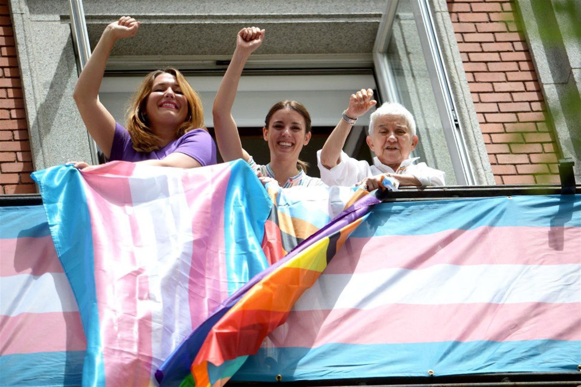 Irene Montero junto a Ángela Rodríguez y Boti García tras colocar banderas trans en la fachada de su ministerio.