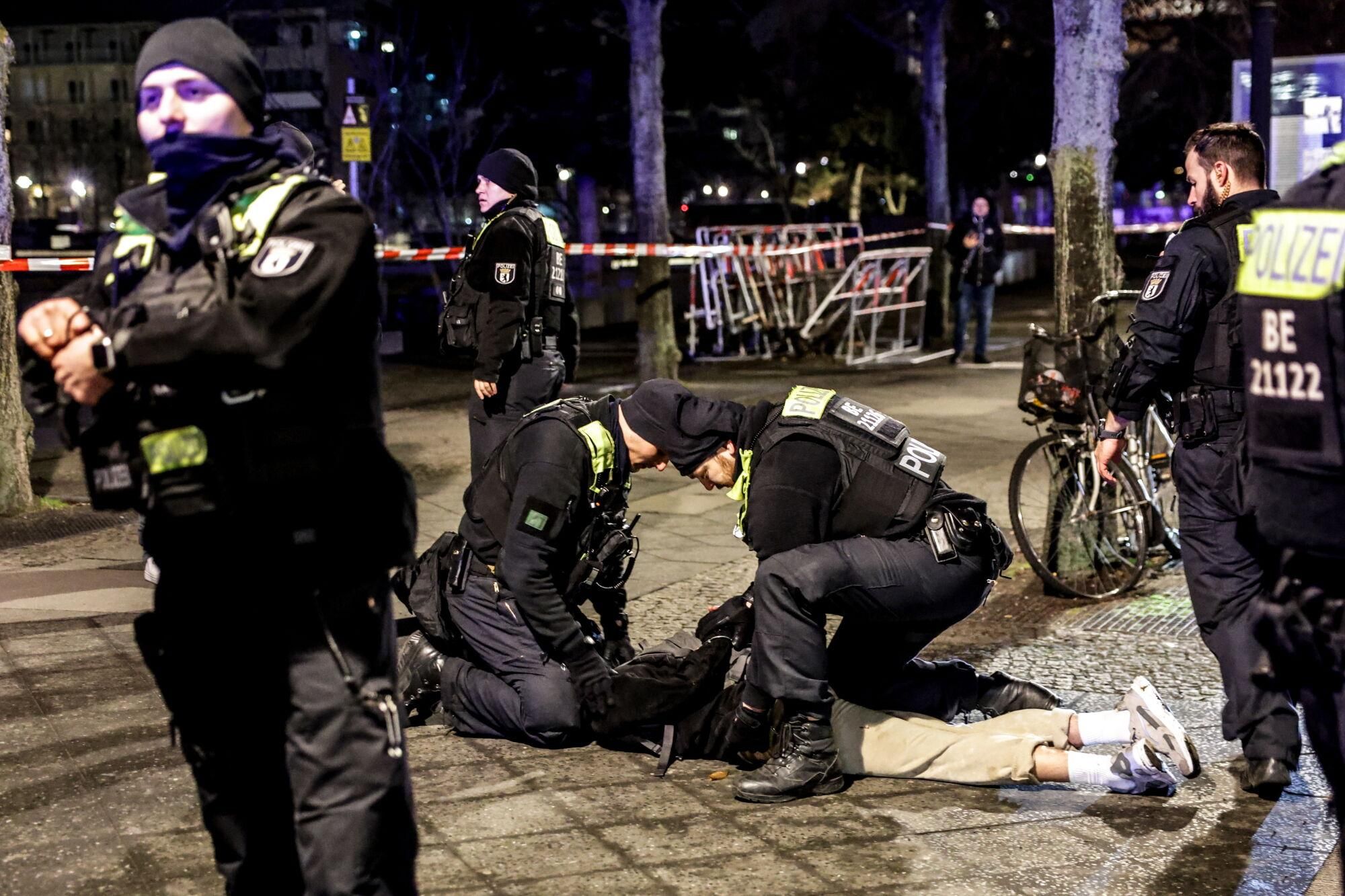 Berlin (Germany), 21/02/2025.- Police officers arrest a man near the Holocaust Memorial in Berlin, Germany, 21 February 2025, after another man was seriously injured with a sharp object. The injured man was taken to hospital and an investigation is ongoing at the crime scene. (Alemania) EFE/EPA/CHRISTOPHER NEUNDORF