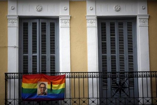 The photo of LGTB rights activist and Spanish Socialist politician Pedro Zerolo hangs next to a black ribbon on a rainbow flag in the quarter of Chueca in Madrid