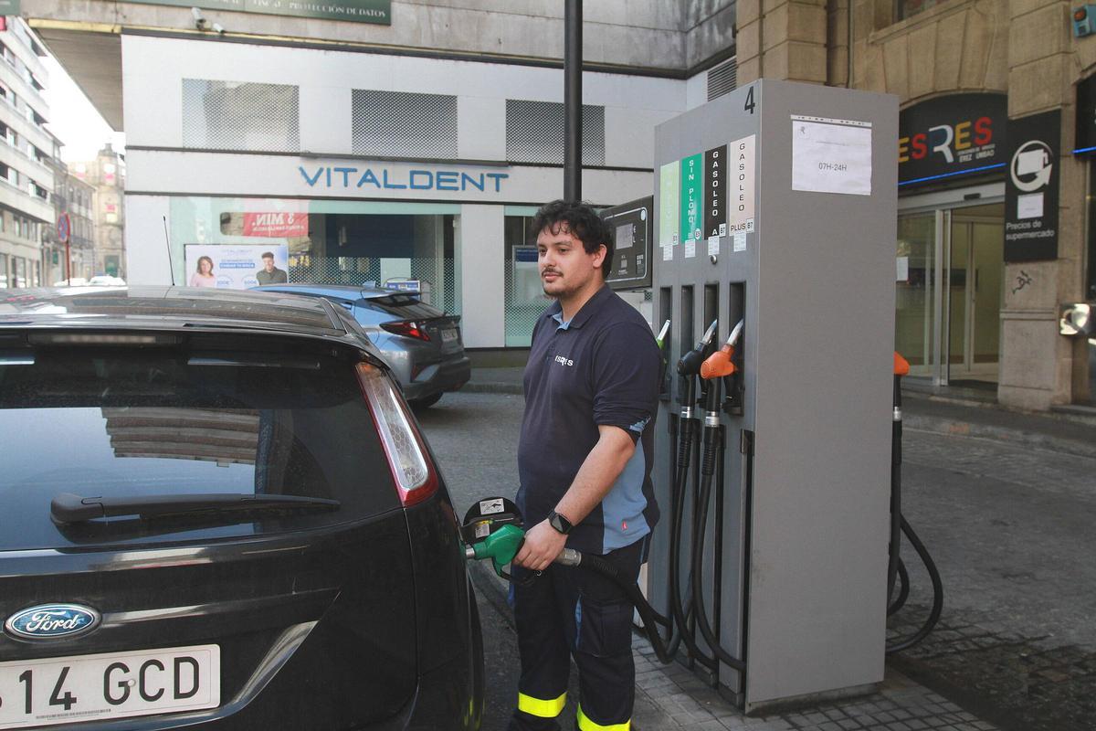 Un trabajador suministra un coche en una estación de servicio de Ourense