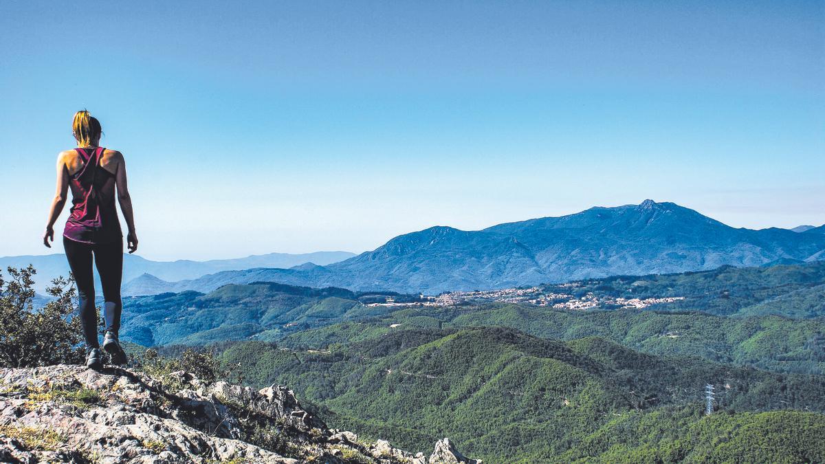 Una mujer observa un paisaje montañoso en el macizo de las Guilleries.