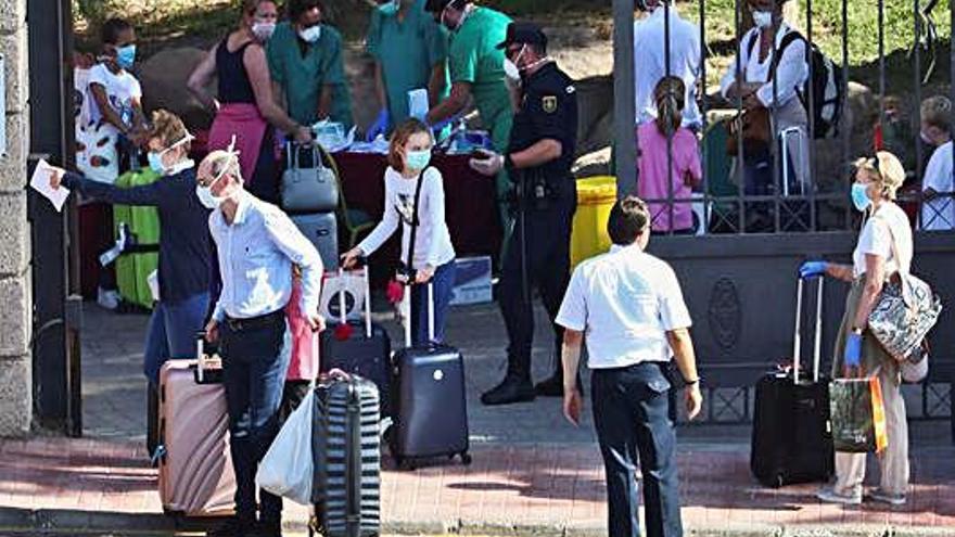 Diversos turistes surten d&#039;un hotel de Costa Adeje (Tenerife) amb mascaretes.