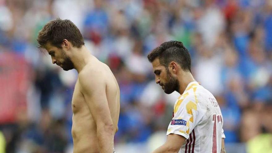 Piqué y Cesc abandonan el campo cabizbajos tras perder con Italia. // Reuters