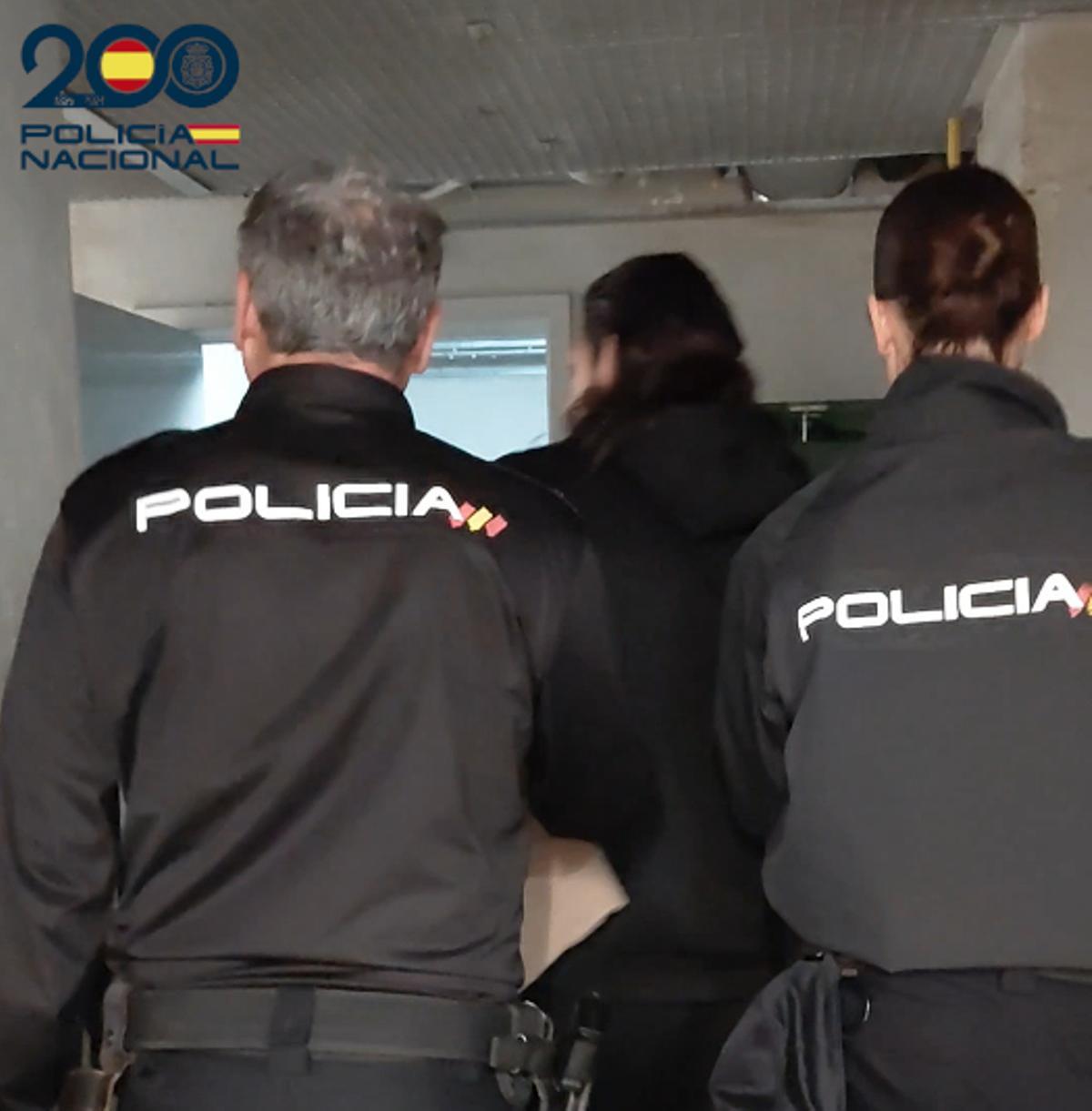 Agentes de la Policía Nacional custodian al detenido por los atracos.