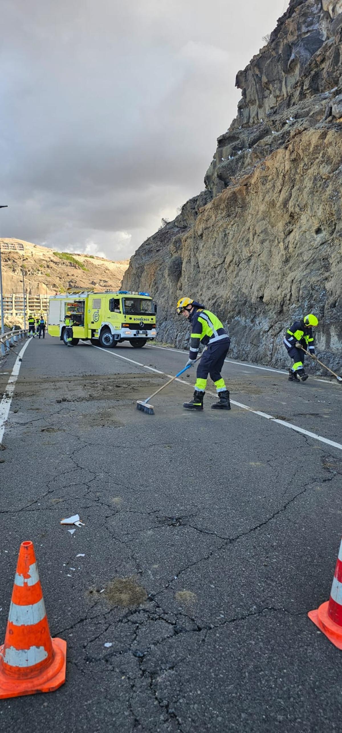 Los efectivos de bomberos limpiando la vía.