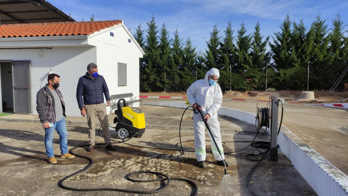 El alcalde de Coria y el concejal observan las labores de desinfección de un operario municipal en el nuevo centro.