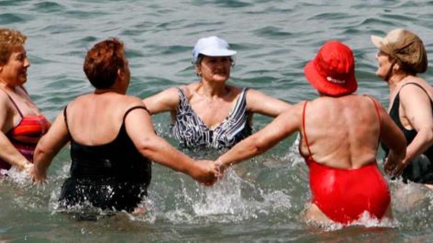Un grupo de turistas mayores, disfrutando de un baño en las playas de Benidorm durante este invierno.