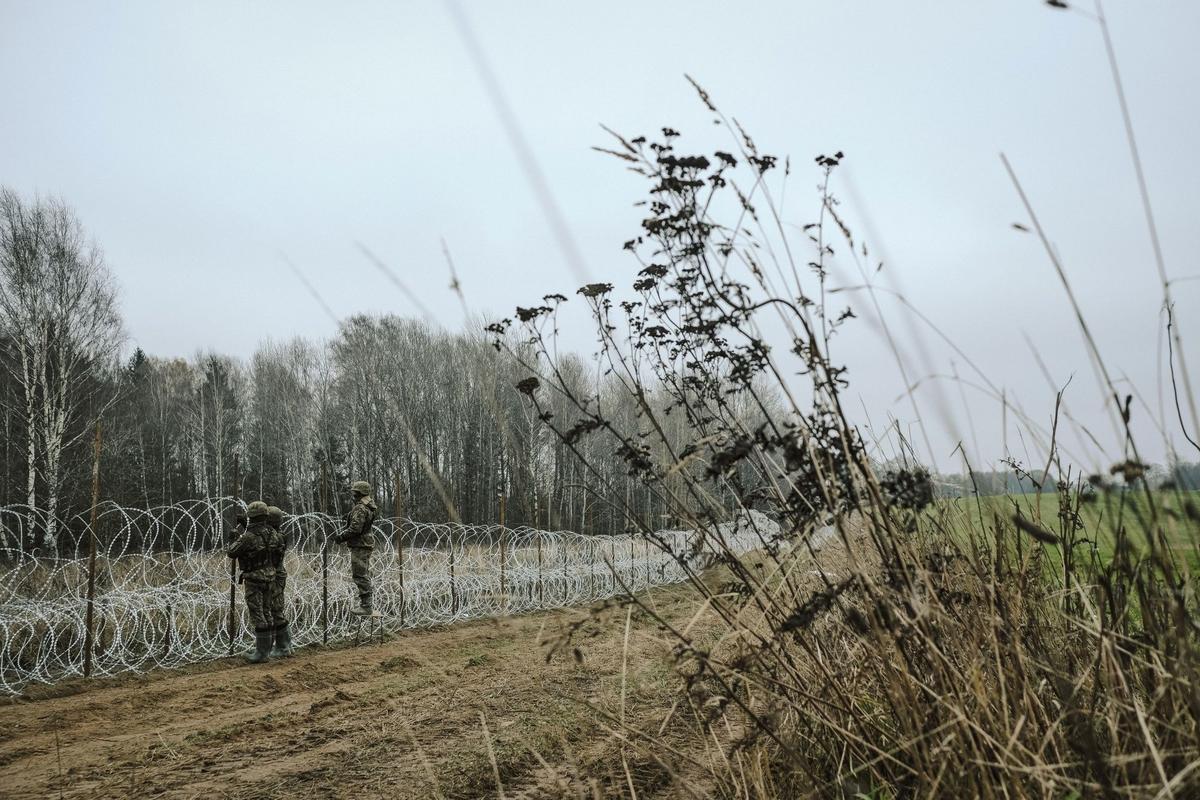 Soldados del ejército polaco arreglan bobinas de alambre de púas en una valla a lo largo de la frontera polaca, con el enclave ruso de Kaliningrado, cerca de Zerdziny, Polonia