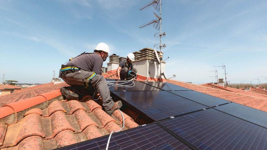 Dos trabajadores de SolarProfit instalan una placa solar fotovoltaica en un tejado. |   // CEDIDA