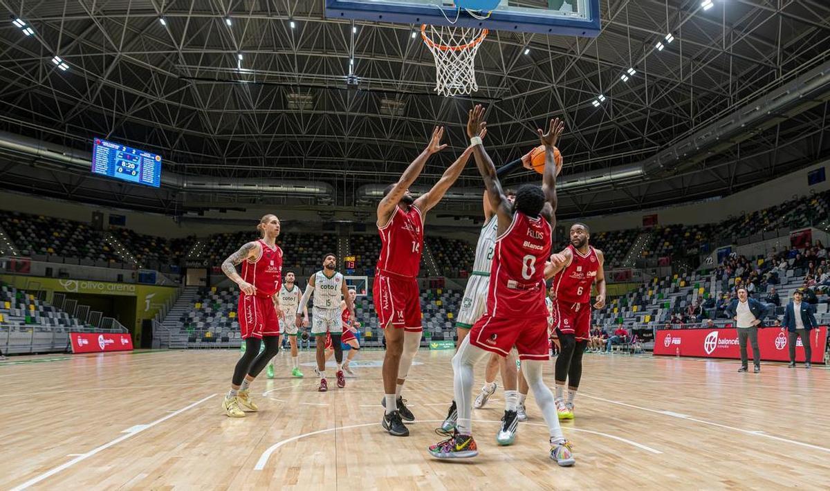 Fernando Bello intenta un lanzamiento ante dos defensores del CB Jaén.