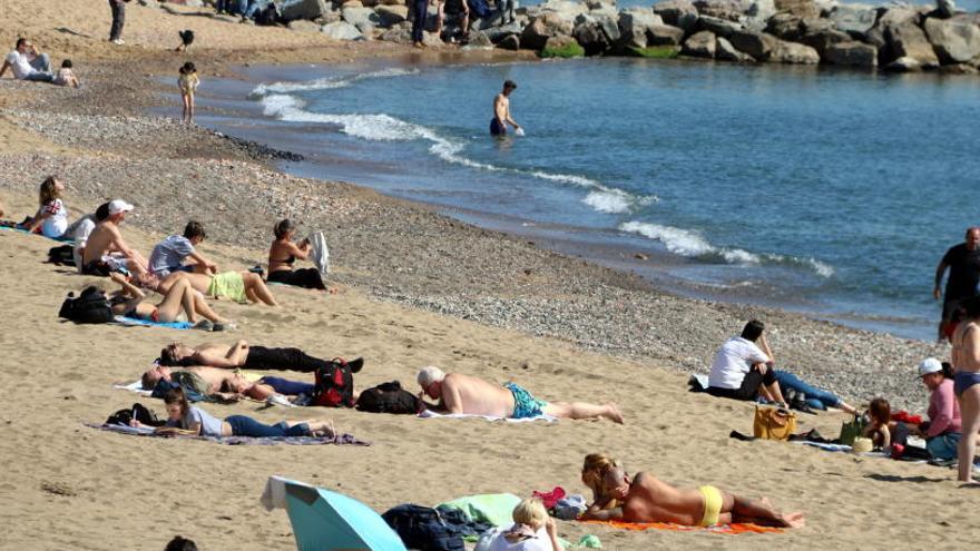 Gent a la platja al mes de Març.