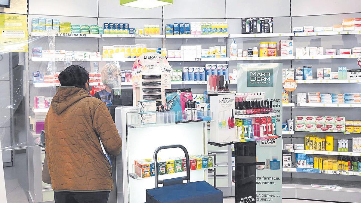 Una mujer es atendida en el mostrador de una farmacia de Murcia.