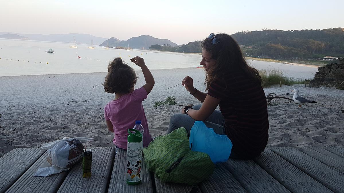 Una joven con una niña en las islas Cíes.