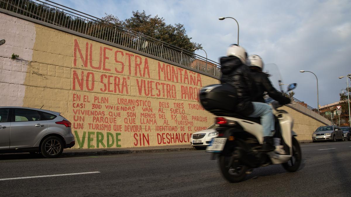 Pintada crítica con el plan urbanístico de los Tres Turons que completa el grafiti de Blu en el Carmel.