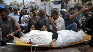 Dos mujeres palestinas abrazan el cadáver de un familiar fallecido en un bombardeo israelí, este jueves en el hospital de Deir el Balah, en Gaza.