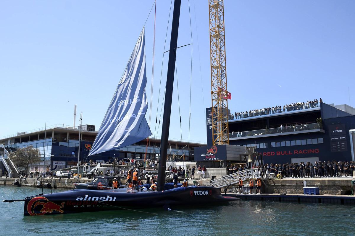 El AC75 de Alinghi Red Bull Racing, el BoatOne, se deposita sobre el agua del Port Vell por primera vez, en la primera botadura en Barcelona de un barco de la Copa América de vela.