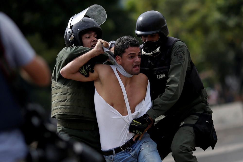 Un manifestante es detenido durante las protestas del 'paro cívico' en Venezuela.