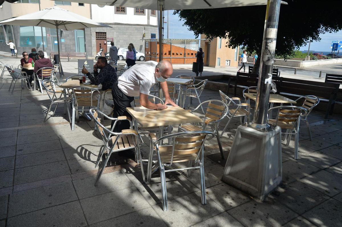 Un camarero limpia una terraza en Las Palmas.