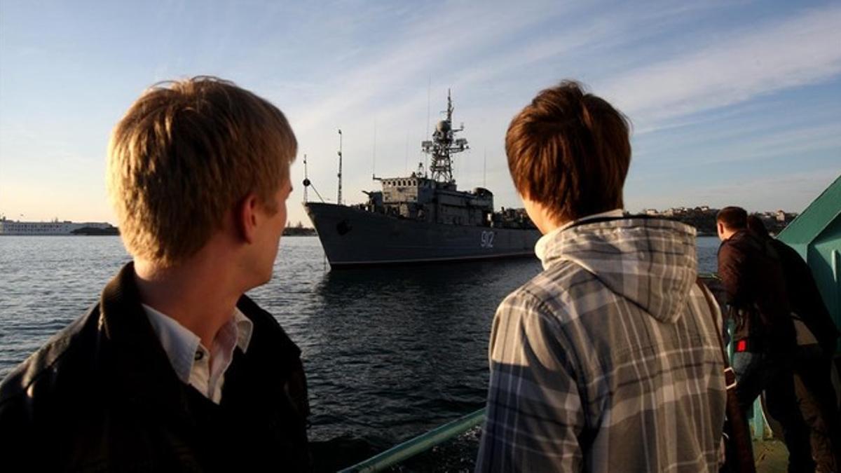 Dos personas observan la nave rusa 'Turbinist' en la bahía de Sebastopol (Crimea), este miércoles.