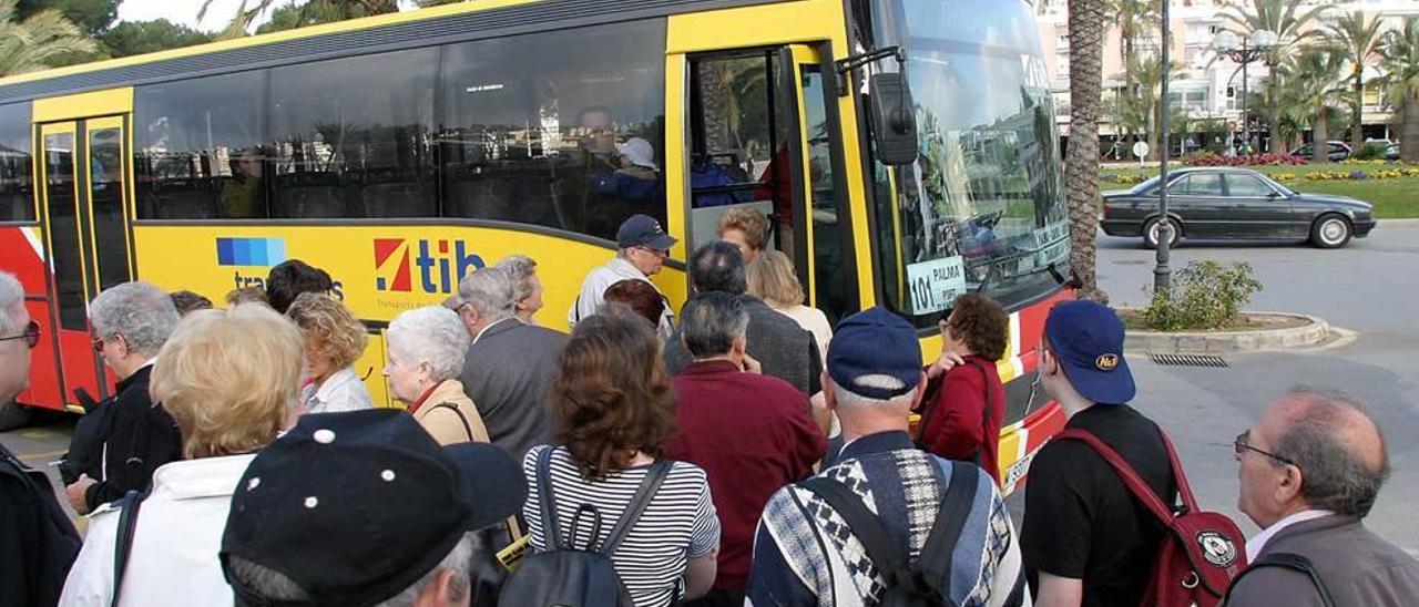 Cola de pasajeros subiendo a uno de los buses del TIB que conectan la isla.