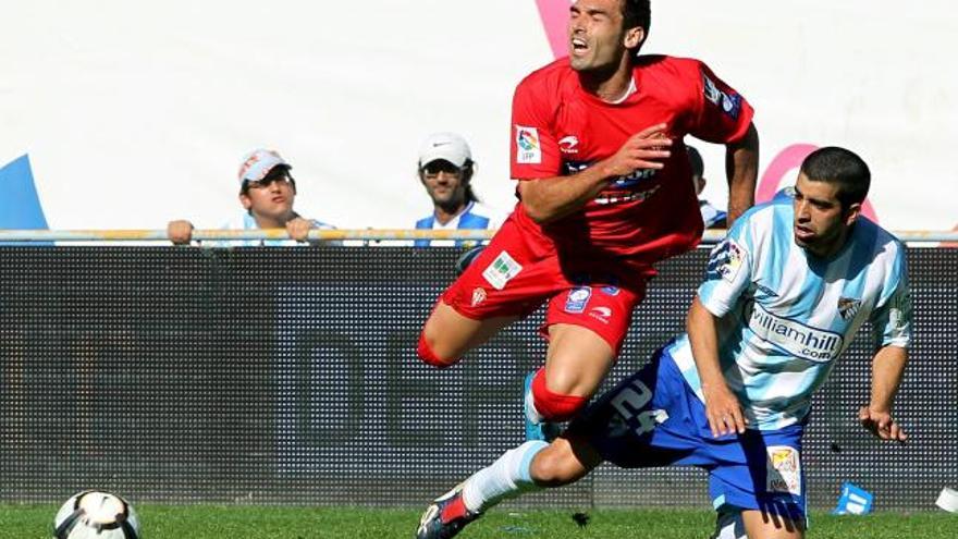 Juanito trata de conseguir un balón frente a David Barral.