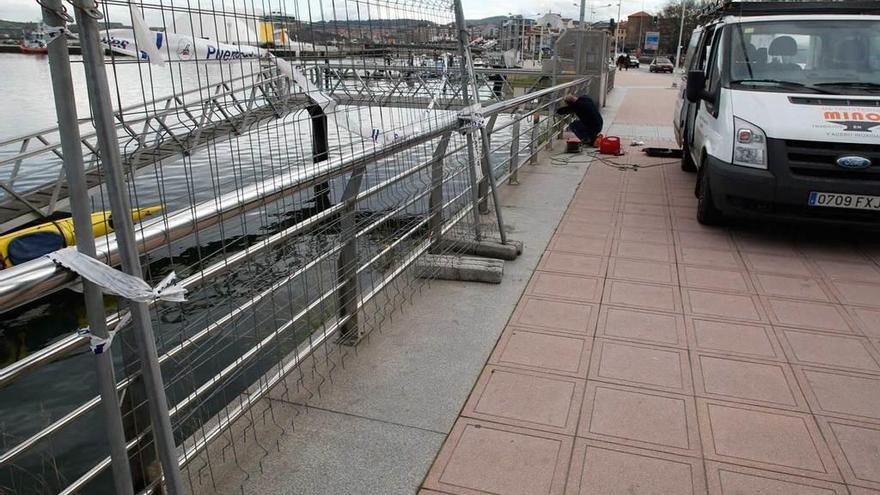 Los operarios, ayer, arreglando la barandilla en la ría.