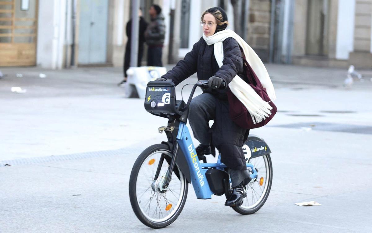 Una joven usando BiciCoruña por el centro de la ciudad. |  Iago López