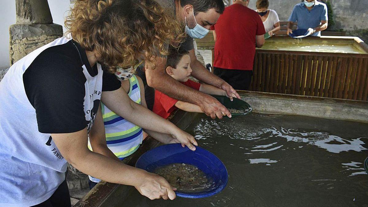 Visitantes en el Museo del Oro de Navelgas, aprendiendo a batear.