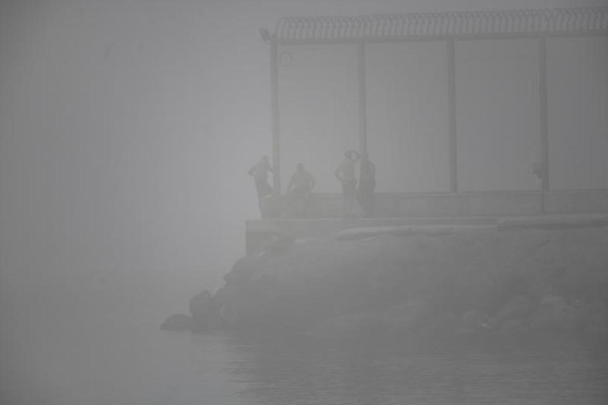 Niebla en el espigón ceutí del Tarajal, durante un repunte de llegadas a nado en julio de 2022.