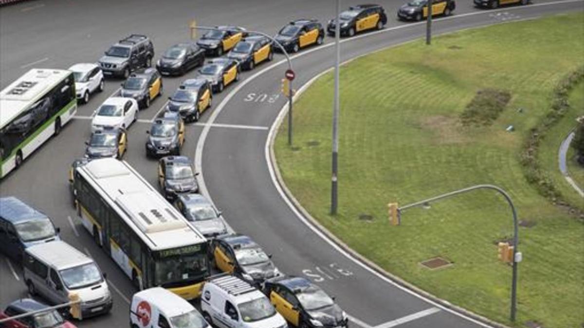 Varios taxis circulan a marcha lenta por la plaza de Espanya.