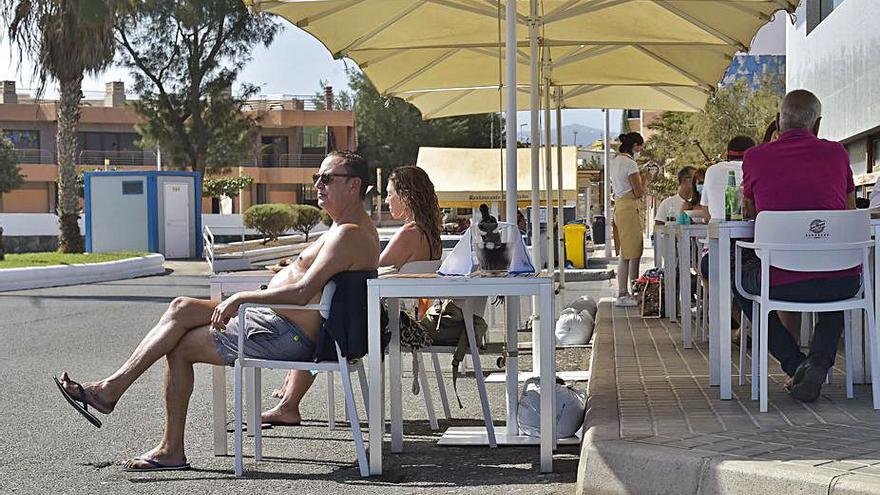 Dos bañistas al sol, en las terrazas de La Garita.