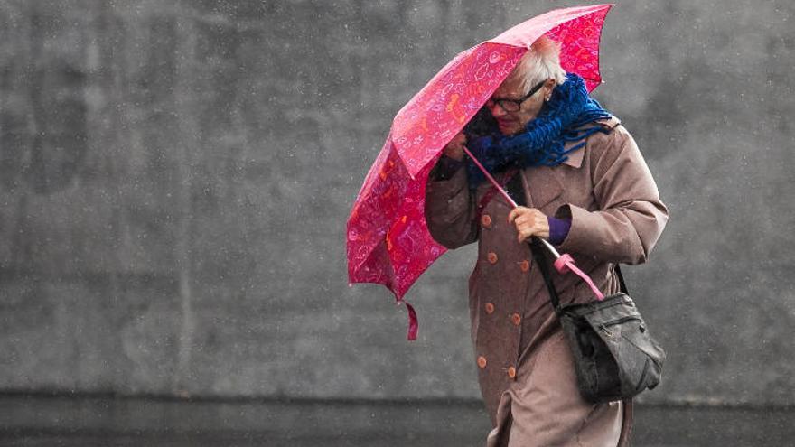 Una mujer durante un temporal anterior de viento y lluvia.