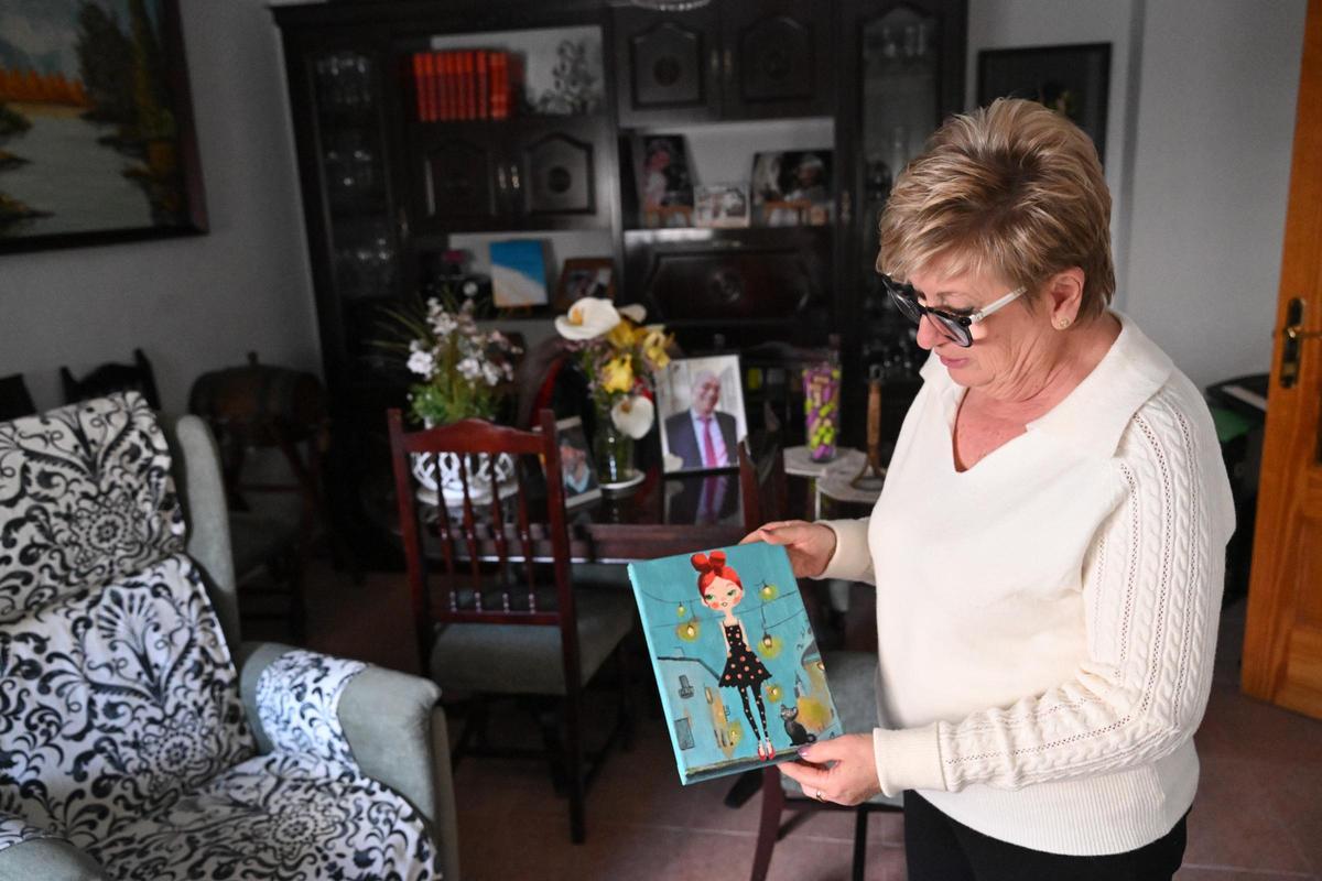 Antonia Álvarez, vecina de Aspe que vive sola muestra una de sus pinturas que ha realizado en un taller municipal.