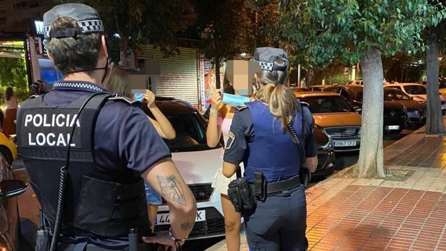 La policía requiere a dos jóvenes que se pongan la mascarilla en Alicante.