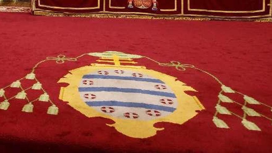Escudo de la Universidad de Oviedo en una alfombra.
