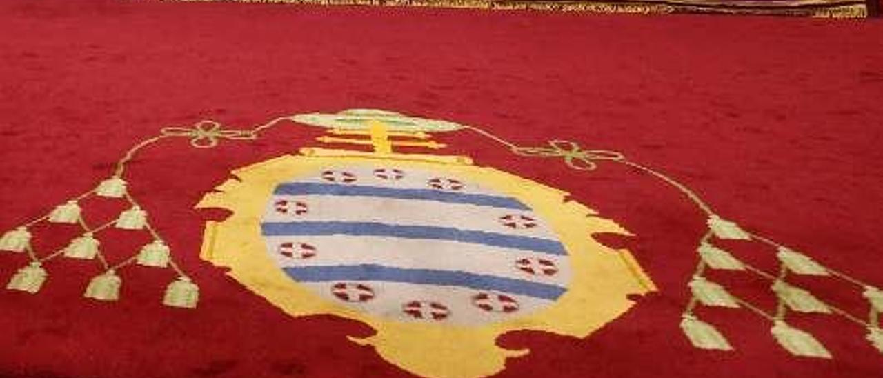 Escudo de la Universidad de Oviedo en una alfombra.