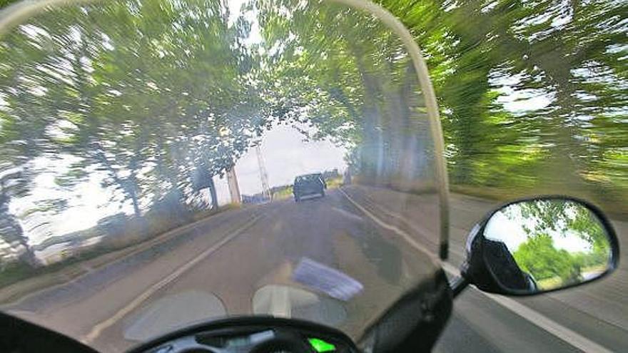 Una moto, circulando por una carretera asturiana.