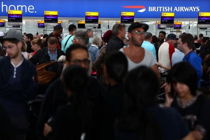 People wait with their luggage at the British ...