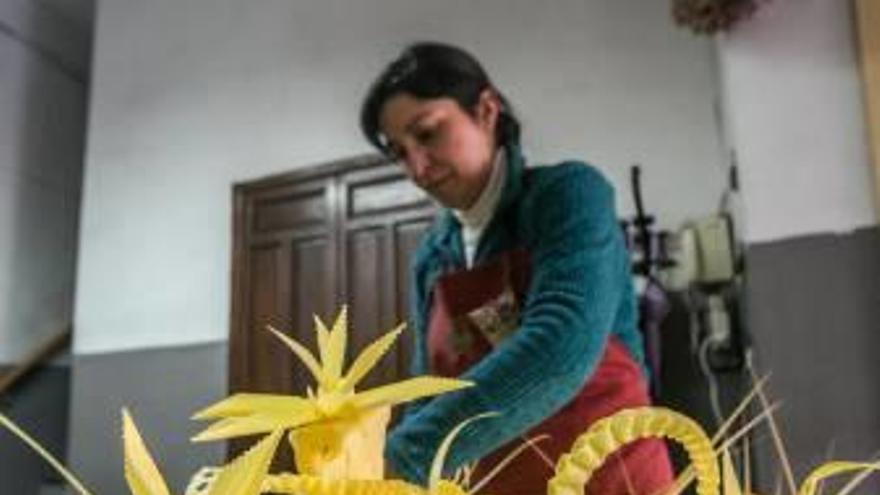 Una artesana de palma blanca elaborando ramos.