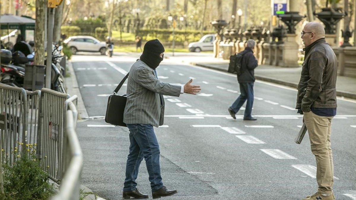 Joaquim Benítez tiende la mano a Manuel Barbero, frente a la Audiencia de Barcelona