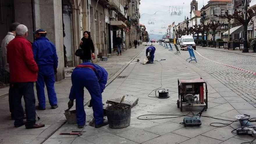 Operarios del Concello reparan la calzada en la Corredoira. // J. V.