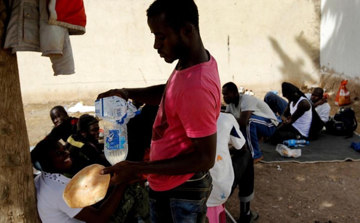 Un dels immigrants es prepara alguna cosa per menjar.