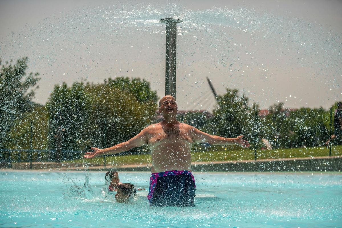 GRAF9292. OURENSE, 14/07/2022.-Un hombre se refresca en las piscinas públicas de Oira, este jueves en Ourense. La sofocante ola de calor que asfixia a España, que persistirá todo lo que queda de semana, activa de nuevo la alerta roja en Galicia, con el epicentro en Ourense; Andalucía, Extremadura y ambas Castillas por temperaturas máximas que pueden alcanzar 44 grados. EFE/Brais Lorenzo