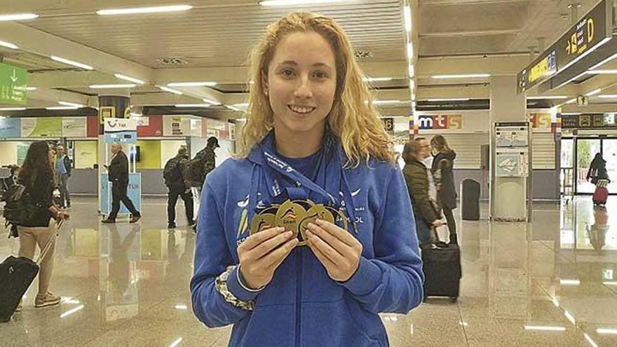 La palmesana Aina Hierro, con sus tres medallas en el Nacional de Gijón, ayer en el aeropuerto de Son Sant Joan.