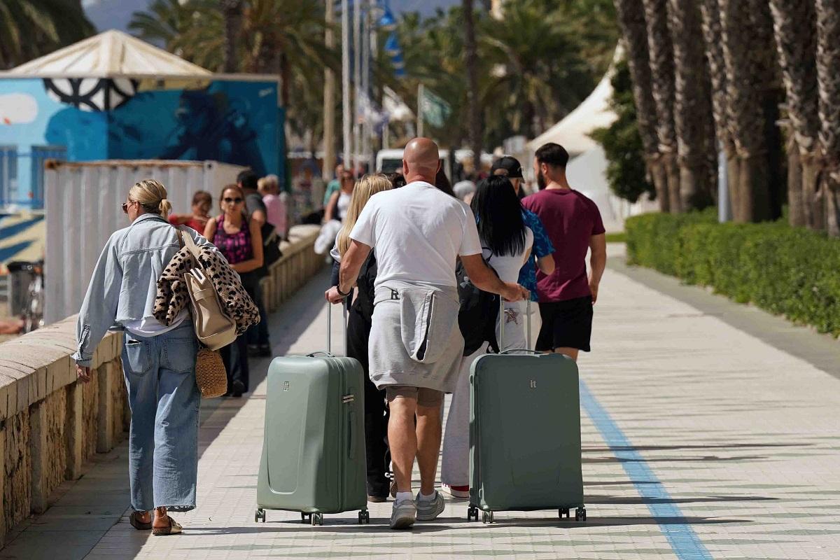 Turistas con sus maletas en uno de los paseos marítimos de Málaga.
