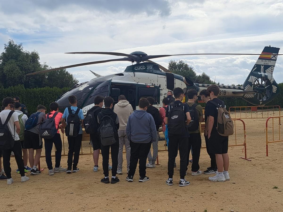 Un grupo de estudiantes ante un helicóptero de la Guardia Civil.