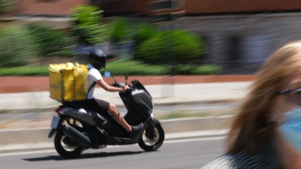 Un repartidor circula por la ciudad en su motocicleta.