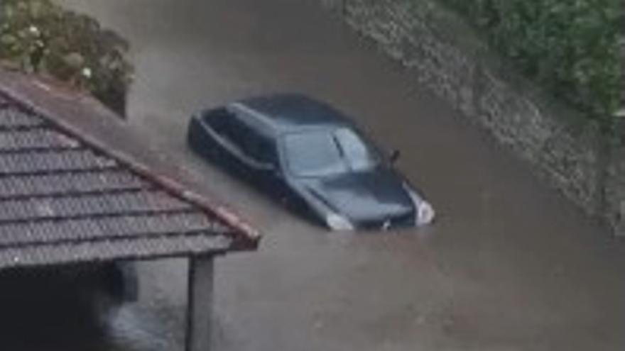 Un coche, atrapado en una 'laguna' urbana provocada por las intensas lluvias caídas este lunes en Caldas de Reis.